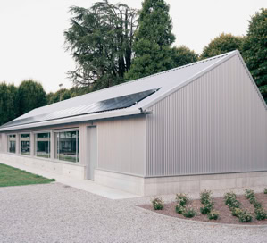 Mensa scolastica pubblica a Villa del Conte (Padova), realizzata per il Comune a servizio del plesso scolastico, con ampie vetrate, copertura a falde e pannelli fotovoltaici.