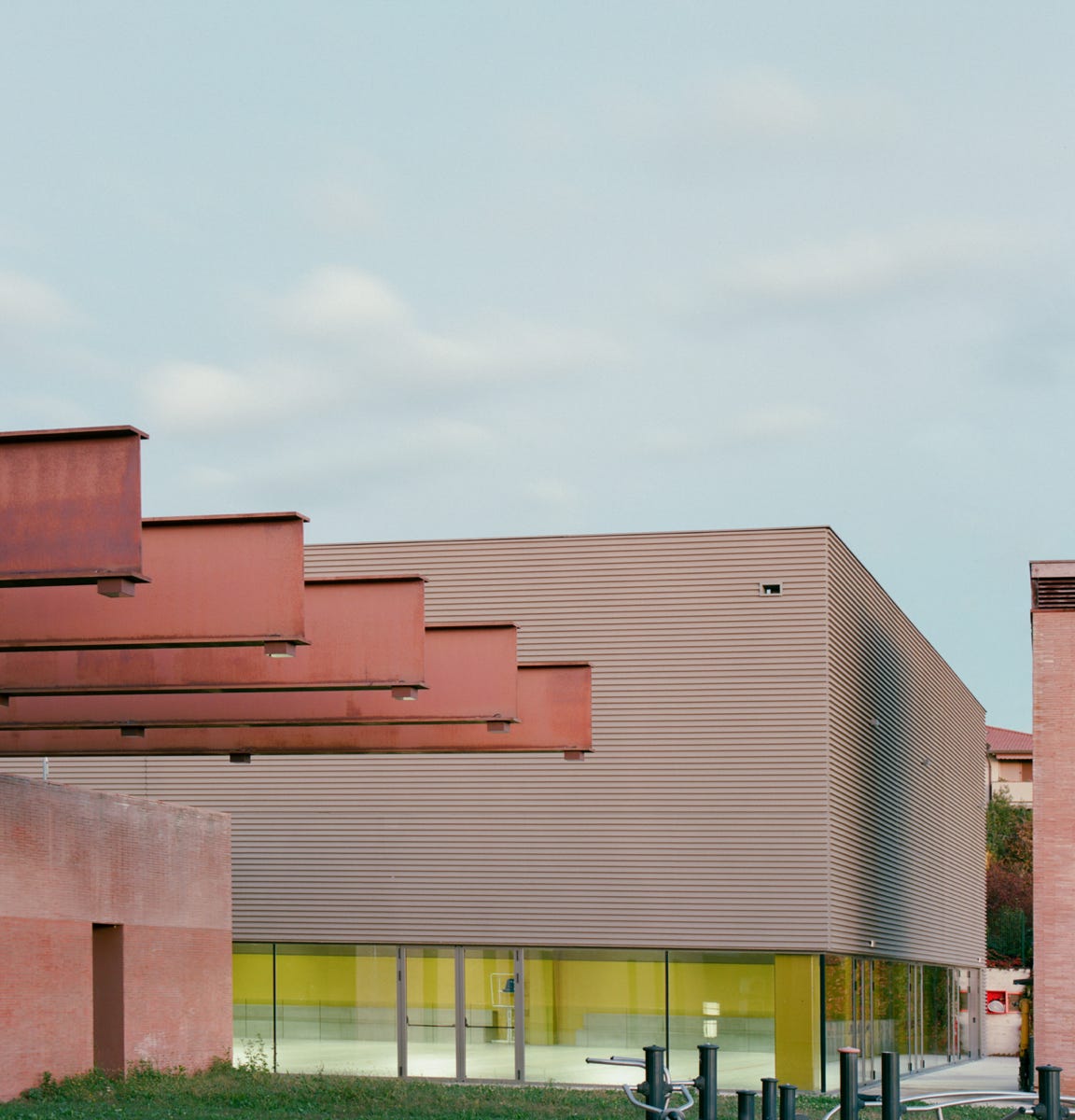 Foto esterni della nuova palestra scolastica a Merate (LC), progettata da MD41, edificio su un piano con grande vetrata e design contemporaneo.