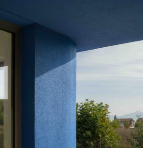 Particolare architettonico degli angoli smussati dell’edificio, che mostrano la transizione morbida tra due pareti blu.