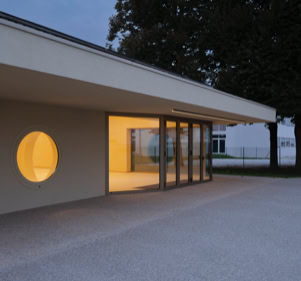 Foto esterni del nuovo polo dell’infanzia a Longare (VI), progettato da MD41, edificio con tetto a falde scultoreo, accessi distinti e ampi spazi esterni.