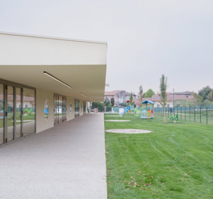 Foto esterni del nuovo polo dell’infanzia a Longare (VI), progettato da MD41, edificio con tetto a falde scultoreo, accessi distinti e ampi spazi esterni. 